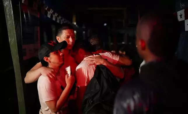 Venezuelan migrants embrace upon their arrival to Bajo Chiquito, after Panamanian border police found them along the Tuquesa River, robbed by armed men following their crossing of the Darién Gap from Colombia en route to the United States, in Bajo Chiquito, Panama, Friday, Nov. 8, 2024. (AP Photo/Matias Delacroix)