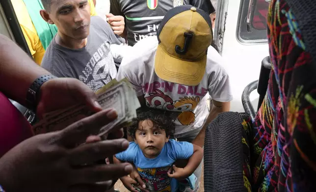 Venezuelan migrant Joana Acosta holds her son Eitan before boarding a bus toward the Costa Rican border, in Lajas Blancas, Panama, after crossing the Darien Gap in hopes of reaching the United States, Sunday, Nov. 10, 2024. (AP Photo/Matias Delacroix)