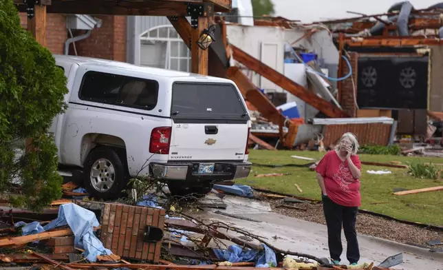 A women stands outside a damaged home after a tornado hit the area in Oklahoma City, Sunday, Nov. 3, 2024. (Bryan Terry/The Oklahoman via AP)