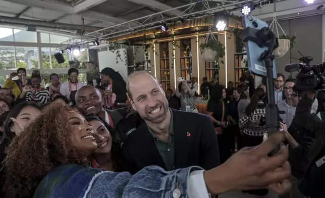 Nomzamo Mbatha, left, the host of Earthshot Week, takes a selfie with Britain's Prince William and a group of young people at the Earthshot Prize Climate Leaders Youth Programme at Rooftop on Bree in Cape Town, South Africa, Monday Nov. 4, 2024. (Gianluigi Guercia/Pool Photo via AP)