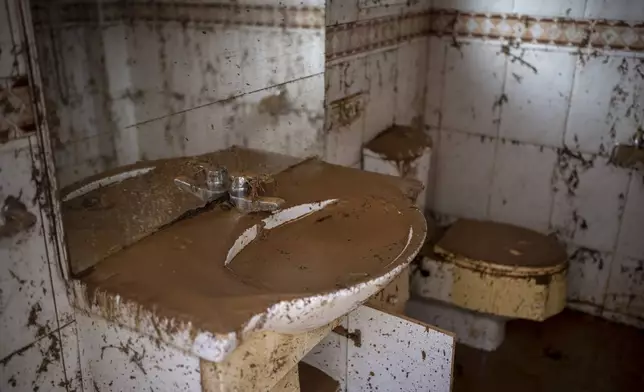 A bathroom is photographed covered in mud after the floods in Masanasa, Valencia, Spain, Thursday, Nov. 7, 2024. (AP Photo/Emilio Morenatti)