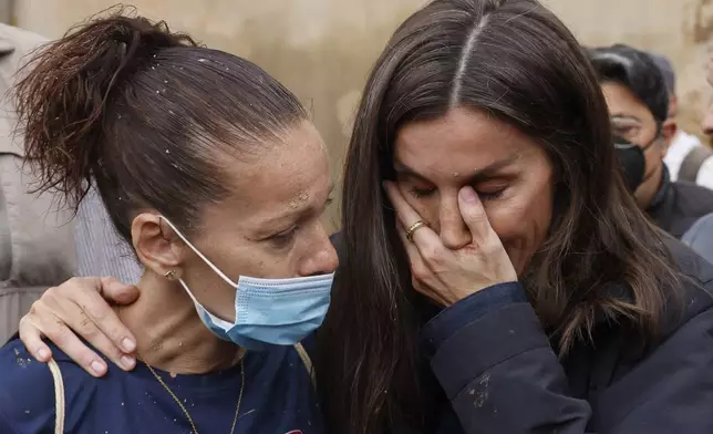 Spain's Queen Letizia reacts as she conforts a woman affected by the floods in Paiporta, near Valencia, Spain, Sunday Nov. 3, 2024. A crowd of angry survivors of Spain's floods have tossed mud and shouted insults at Spain's King Felipe VI and government officials when they made their first visit to one of the hardest hit towns. (Ana Escobar/EFE via AP)