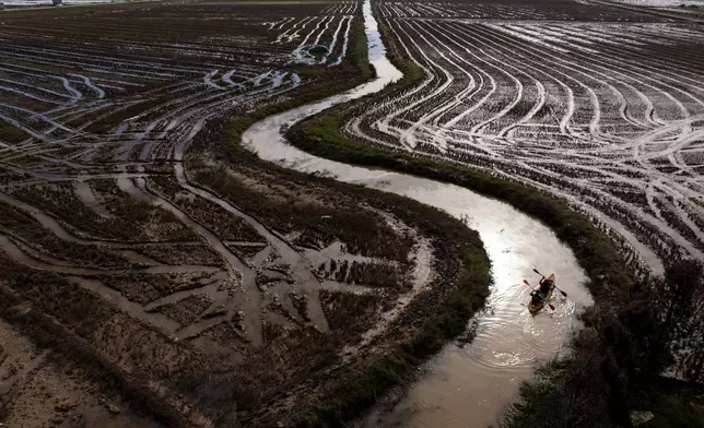 Members of the V battalion of the military emergency unit, UME, use a canoe to search the area for bodies washed away by the floods in the outskirts of Valencia, Spain, Friday, Nov. 8, 2024. (AP Photo/Emilio Morenatti)