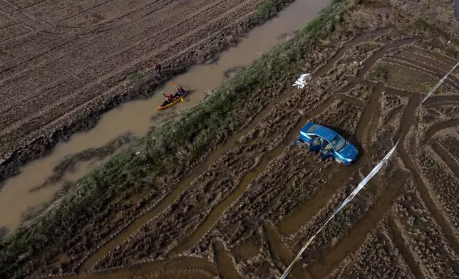 Members of the V battalion of the military emergency unit, UME, use a canoe to search the area for bodies washed away by the floods in the outskirts of Valencia, Spain, Friday, Nov. 8, 2024. (AP Photo/Emilio Morenatti)