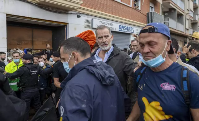 Spain's King Felipe VI, centre, walks amidst angry Spanish flood survivors in Paiporta, near Valencia, Spain, Sunday Nov. 3, 2024. (AP Photo/David Melero)