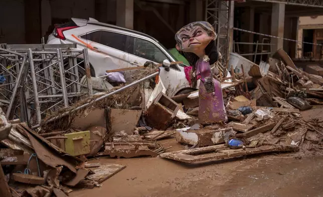 A "Falla" figure structure made of cardboard and other materials is damaged in an area affected by floods in Catarroja, Spain, on Monday, Nov. 4, 2024. (AP Photo/Manu Fernandez)