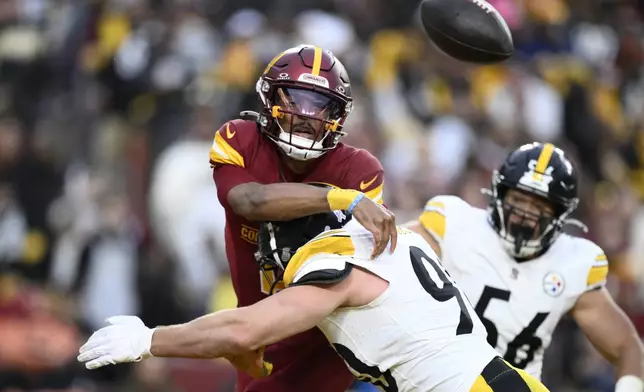 Washington Commanders quarterback Jayden Daniels is pressured by Pittsburgh Steelers linebacker T.J. Watt (90) during the second half of an NFL football game, Sunday, Nov. 10, 2024, in Landover, Md. (AP Photo/Nick Wass)