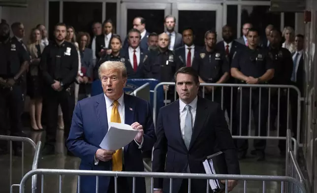 Former President Donald Trump, standing with defense attorney Todd Blanche, speaks at the conclusion of proceedings for the day at his trial at Manhattan criminal court, Tuesday, May 14, 2024, in New York. (AP Photo/Craig Ruttle, Pool)