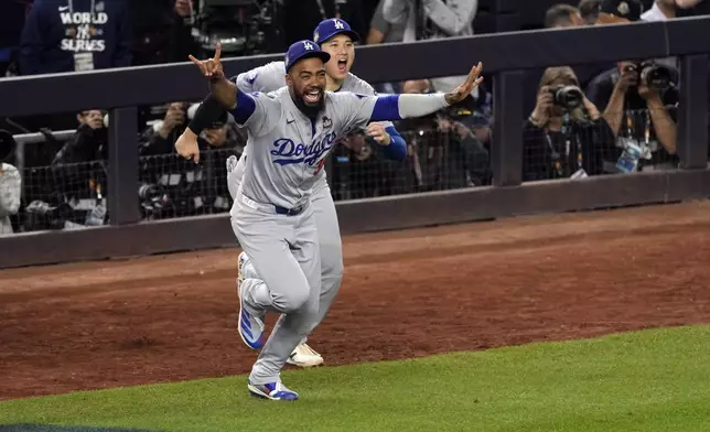 Los Angeles Dodgers' Teoscar Hernández (37) and Shohei Ohtani celebrate after the Dodgers beat the New York Yankees in Game 5 to win the baseball World Series, Wednesday, Oct. 30, 2024, in New York. (AP Photo/Seth Wenig)