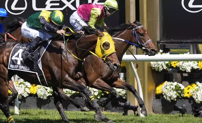 Knight's Choice, right, ridden by Robbie Dolan, crosses the finish line to win the Melbourne Cup horse race ahead of Warp Speed, ridden by Akira Sugawara, at Flemington Racecourse in Melbourne, Australia, Tuesday, Nov. 5, 2024. (AP Photo/Asanka Brendon Ratnayake)