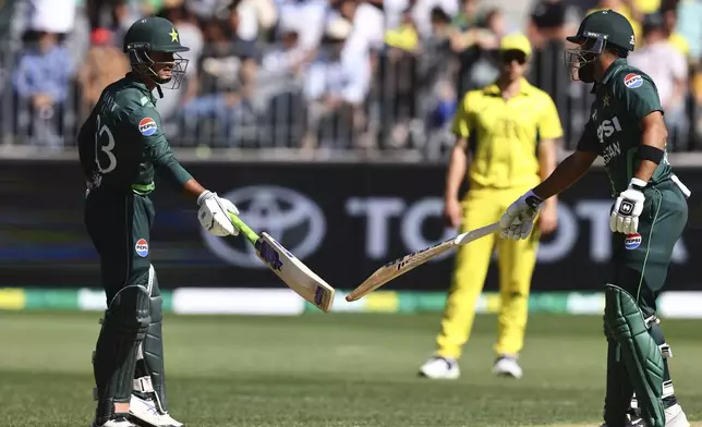 Pakistan's batting partners Saim Ayub, left, and Abdullah Shafique touch bats between deliveries from Australia during their one day international cricket match in Perth, Australia, Sunday, Nov. 10, 2024. (AP Photo/Trevor Collens)