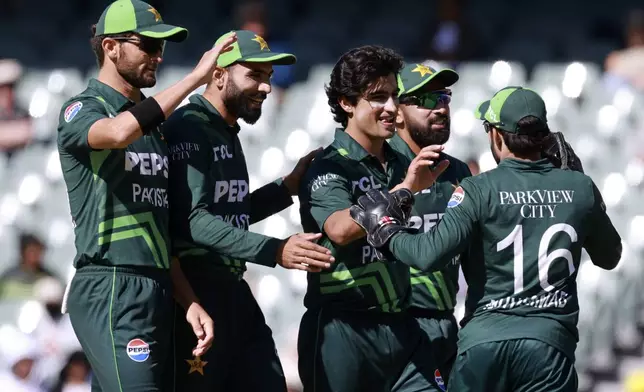 Pakistan's Naseem Shah, center, is congratulated by teammates after taking the wicket of Australia's Mitchell Starc during their one day international cricket match in Adelaide, Australia, Friday, Nov. 8, 2024. (AP Photo/James Elsby)