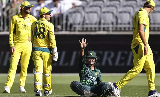 Pakistan's Saim Ayub, second right, calls for assistance after he was struck by a ball during their one day international cricket match against Australia in Perth, Australia, Sunday, Nov. 10, 2024. (AP Photo/Trevor Collens)