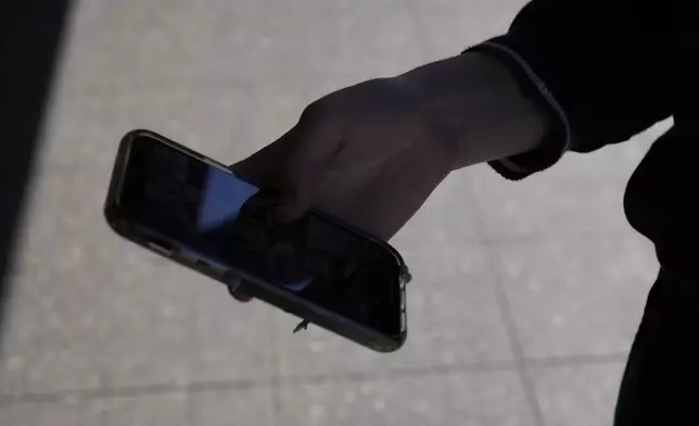 A teenage girl uses her phone in Sydney, Friday, Nov. 8, 2024. (AP Photo/Rick Rycroft)