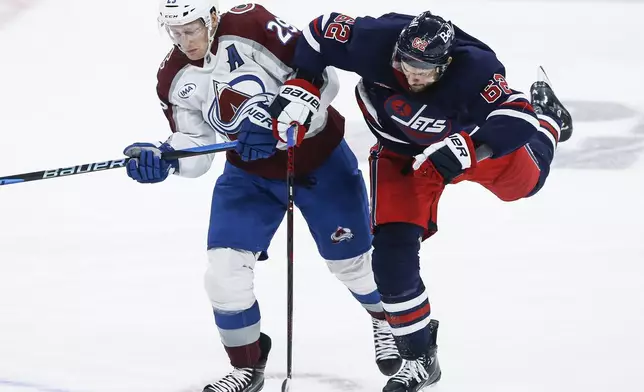 Winnipeg Jets' Nino Niederreiter (62) and Colorado Avalanche's Nathan MacKinnon (29) collide during the third period of an NHL hockey game Thursday, Nov. 7, 2024 in Winnipeg, Manitoba. (John Woods/The Canadian Press via AP)