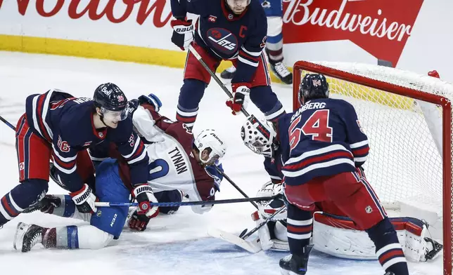 Winnipeg Jets goaltender Connor Hellebuyck (37) saves the shot from Colorado Avalanche's T.J. Tynan (9) during the third period of an NHL hockey game Thursday, Nov. 7, 2024 in Winnipeg, Manitoba. (John Woods/The Canadian Press via AP)