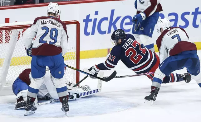 Winnipeg Jets' Nikolaj Ehlers (27) tries to get his stick on a loose puck in front of Colorado Avalanche goaltender Alexandar Georgiev (40) during the third period of an NHL hockey game Thursday, Nov. 7, 2024 in Winnipeg, Manitoba. (John Woods/The Canadian Press via AP)