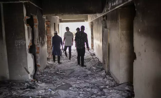 Protesters walk through ransacked Awami League party office in Dhaka, Bangladesh, Sunday, Nov. 10, 2024. (AP Photo/Mahmud Hossain Opu)