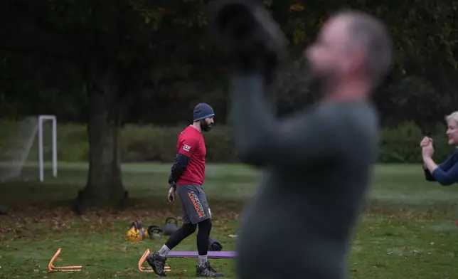 Personal fitness trainer Richard Lamb, leads a group in an outdoor gym class in London, Saturday, Oct. 26, 2024. (AP Photo/Alastair Grant)