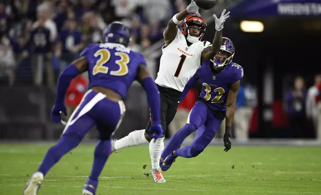 Cincinnati Bengals wide receiver Ja'Marr Chase (1) catches the ball as Baltimore Ravens linebacker Trenton Simpson (23) and safety Marcus Williams (32) move in during the first half of an NFL football game, Thursday, Nov. 7, 2024, in Baltimore. (AP Photo/Nick Wass)