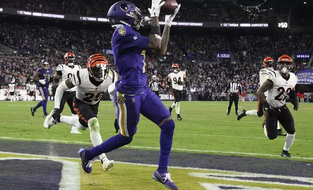 Baltimore Ravens wide receiver Rashod Bateman (7) catches a pass for a touchdown past Cincinnati Bengals cornerback Cam Taylor-Britt (29) and safety Geno Stone (22) during the second half of an NFL football game, Thursday, Nov. 7, 2024, in Baltimore. (AP Photo/Nick Wass)