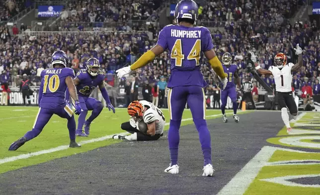 Cincinnati Bengals tight end Tanner Hudson (87) scores a touchdown as Baltimore Ravens cornerback Arthur Maulet (10), linebacker Trenton Simpson (23), and cornerback Marlon Humphrey (44) look on during the first half of an NFL football game, Thursday, Nov. 7, 2024, in Baltimore. Cincinnati Bengals wide receiver Ja'Marr Chase (1) celebrates. (AP Photo/Stephanie Scarbrough)