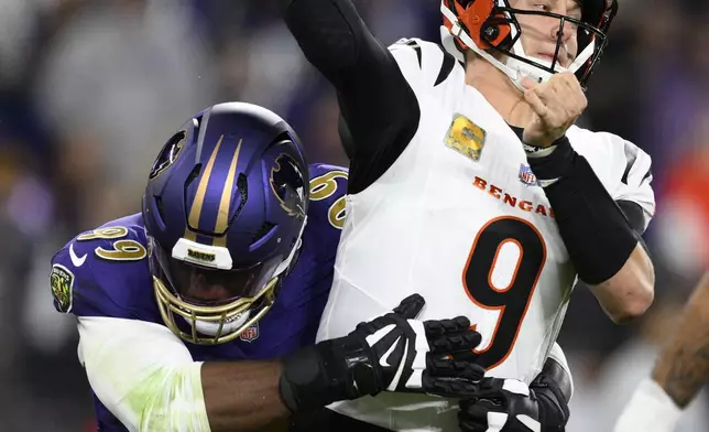 Baltimore Ravens linebacker Odafe Oweh, left, pressures Cincinnati Bengals quarterback Joe Burrow (9) as he passes the ball during the first half of an NFL football game, Thursday, Nov. 7, 2024, in Baltimore. (AP Photo/Nick Wass)