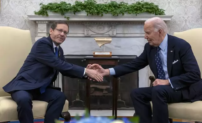 President Joe Biden shakes hands with Israel's President Isaac Herzog, left, during a meeting in the Oval Office of the White House in Washington, Tuesday, Nov. 12, 2024. (AP Photo/Ben Curtis)