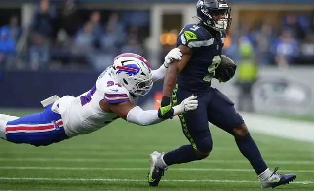 Seattle Seahawks running back Kenneth Walker III (9) runs the ball against Buffalo Bills defensive end Dawuane Smoot (94) during the first half of an NFL football game, Sunday, Oct. 27, 2024, in Seattle. (AP Photo/Lindsey Wasson)