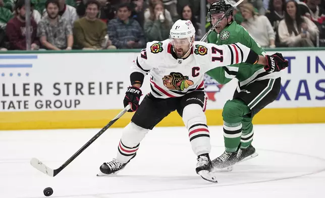 Chicago Blackhawks left wing Nick Foligno (17) takes control of the puck on a breakaway play as Dallas Stars' Thomas Harley, rear defends in the second period of an NHL hockey game in Dallas, Thursday, Nov. 7, 2024. (AP Photo/Tony Gutierrez)