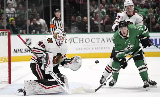 Chicago Blackhawks goaltender Arvid Soderblom (40) defends against a shot as defenseman Alex Vlasic (72) helps against pressure from Dallas Stars' Logan Stankoven (11) in the first period of an NHL hockey game in Dallas, Thursday, Nov. 7, 2024. (AP Photo/Tony Gutierrez)