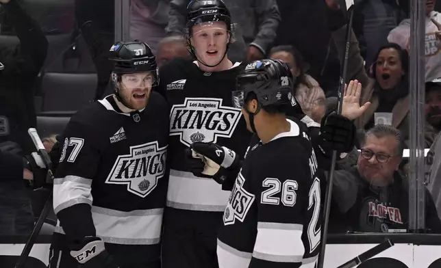 Los Angeles Kings left wing Warren Foegele celebrates scoring a goal with center Akil Thomas (26) and Samuel Helenius, center, against the Columbus Blue Jackets during the second period of an NHL hockey game in Los Angeles, Saturday, Nov. 9, 2024. (AP Photo/Alex Gallardo)