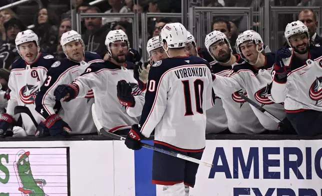 Columbus Blue Jackets left wing Dmitri Voronkov (10) celebrates after scoring a goal against the Los Angeles Kings with teammates on the bench during the first period of an NHL hockey game in Los Angeles, Saturday, Nov. 9, 2024. (AP Photo/Alex Gallardo)