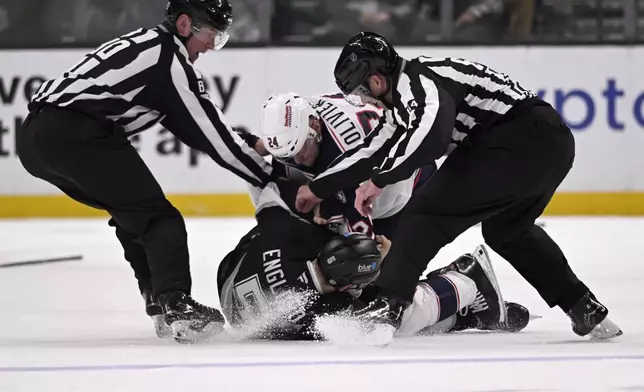 linesman Jonathan Deschamps (80) and linesman Brandon Gawryletz (64) break up a fight between Columbus Blue Jackets right wing Mathieu Olivier (24) and Los Angeles Kings defenseman Andreas Englund (5) during the second period of an NHL hockey game in Los Angeles, Saturday, Nov. 9, 2024. (AP Photo/Alex Gallardo)