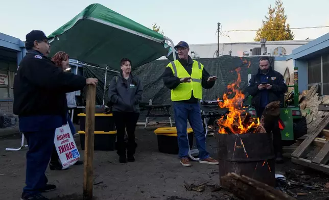 Boeing employees gather around a burn barrel as others arrive to vote on a new contract offer from the company Monday, Nov. 4, 2024, at the Aerospace Machinists Union hall in Renton, Wash. (AP Photo/Lindsey Wasson)