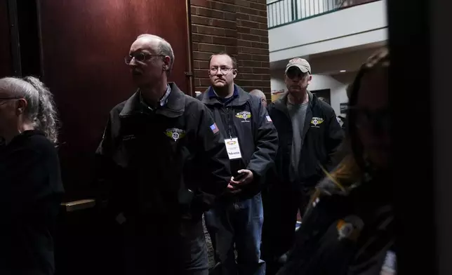 Workers listen as IAM District 751 president Jon Holden gives a press conference after announcing the union voted to accept a new contract offer from Boeing, Monday, Nov. 4, 2024, at their union hall in Seattle. (AP Photo/Lindsey Wasson)