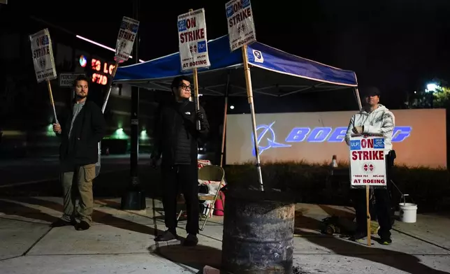 From left, Boeing employees Vance Meyring, Josue Ramirez and Joseph Mellon work the picket line after union members voted to reject a new contract offer from the company, Wednesday, Oct. 23, 2024, outside Boeing facilities in Renton, Wash. (AP Photo/Lindsey Wasson)