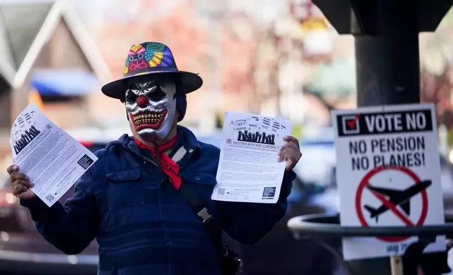 EDS NOTE: OBSCENITY - A Boeing employee holds up flyers encouraging others to vote no on a new contract offer from the company, Monday, Nov. 4, 2024, in Everett, Wash. (AP Photo/Lindsey Wasson)