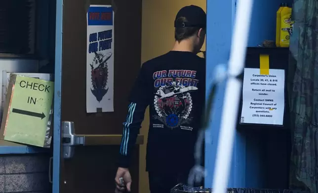 A Boeing employee, wearing a union shirt, arrives to vote on a new contract offer from the company, Monday, Nov. 4, 2024, at the Aerospace Machinists Union hall in Renton, Wash. (AP Photo/Lindsey Wasson)