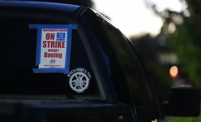 A truck displays a small strike sign in the parking lot of the Aerospace Machinists Union hall as Boeing employees arrive to vote on a new contract offer from the company Monday, Nov. 4, 2024, in Renton, Wash. (AP Photo/Lindsey Wasson)