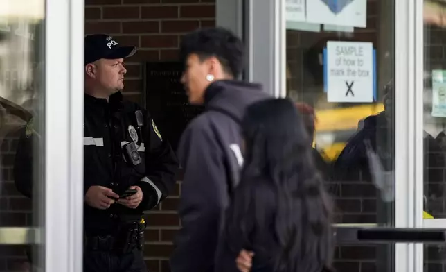 An Everett police officer stands inside the Angel of the Winds Arena as Boeing employees arrive to vote on a new contract offer from the company, Monday, Nov. 4, 2024, in Everett, Wash. (AP Photo/Lindsey Wasson)