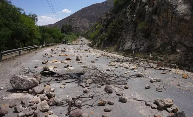 Stones and debris lie on the road after supporters of Bolivian former President Evo Morales placed them there to prevent him from facing a criminal investigation over allegations of abuse of a minor and to demonstrate against an alleged assassination attempt, near Cochabamba, Bolivia, Sunday, Oct. 27, 2024. (AP Photo/Juan Karita)