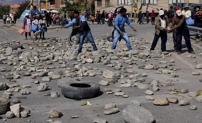 Supporters of Bolivian former President Evo Morales block a road with stones to prevent him from facing a criminal investigation over allegations of abuse of a minor and to demonstrate against an alleged assassination attempt, near Cochabamba, Bolivia, Monday, Oct. 28, 2024. (AP Photo/Juan Karita)