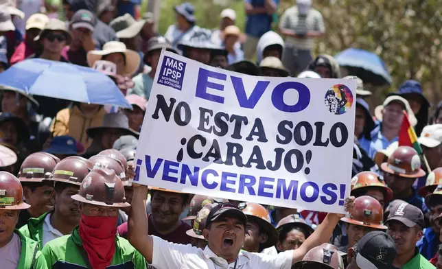 A supporter of Bolivian former President Evo Morales holds a sign with a message that reads in Spanish: " Evo, you are not alone, we will overcome" during a protest to prevent him from facing a criminal investigation over allegations of abuse of a minor and to demonstrate against an alleged assassination attempt, in Parotani, Bolivia, Tuesday, Oct. 29, 2024. (AP Photo/Juan Karita)