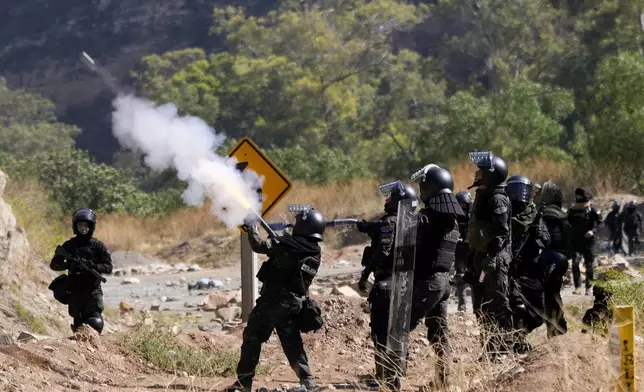 Police launch tear gas to disperse supporters of former President Evo Morales who have been blocking roads for days to prevent him from facing a criminal investigation over allegations of abuse of a minor while he was in office, in Parotani, Bolivia, Friday, Nov. 1, 2024. (AP Photo/Juan Karita)