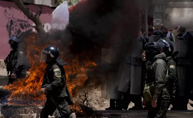 Police arrive to clear roads blocked by supporters of former President Evo Morales, to prevent him from facing a criminal investigation over allegations of abuse of a minor while he was in office, in Parotani, Bolivia, Friday, Nov. 1, 2024. (AP Photo/Juan Karita)