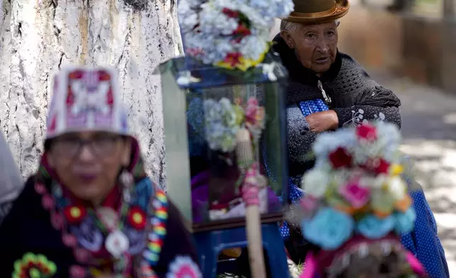 Women stand next to decorated human skulls at the General Cemetery as part of the annual "Ñatitas" festival, a tradition marking the end of the Catholic holiday of All Saints in La Paz, Bolivia, Friday, Nov. 8, 2024. (AP Photo/Juan Karita)