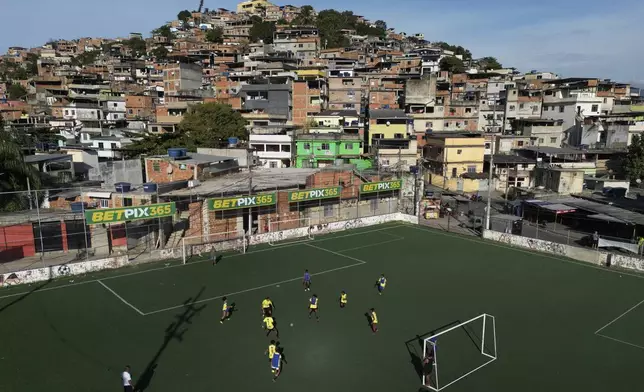 Betting company advertisements adorn a soccer field during a training program run by non-governmental organization "Cara a Cara" in the Complexo do Alemao favela, in Rio de Janeiro, Brazil, Saturday, July 1, 2023. (AP Photo/Bruna Prado)