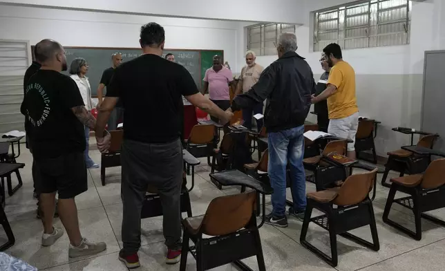 Gamblers in recovery pray during a Gamblers Anonymous meeting in Sao Paulo, Monday, Oct. 21, 2024. (AP Photo/Andre Penner)