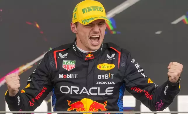 Red Bull driver Max Verstappen, of the Netherlands, celebrates on the podium his first place in the Brazilian Formula One Grand Prix at the Interlagos race track in Sao Paulo, Sunday, Nov. 3, 2024. (AP Photo/Andre Penner)